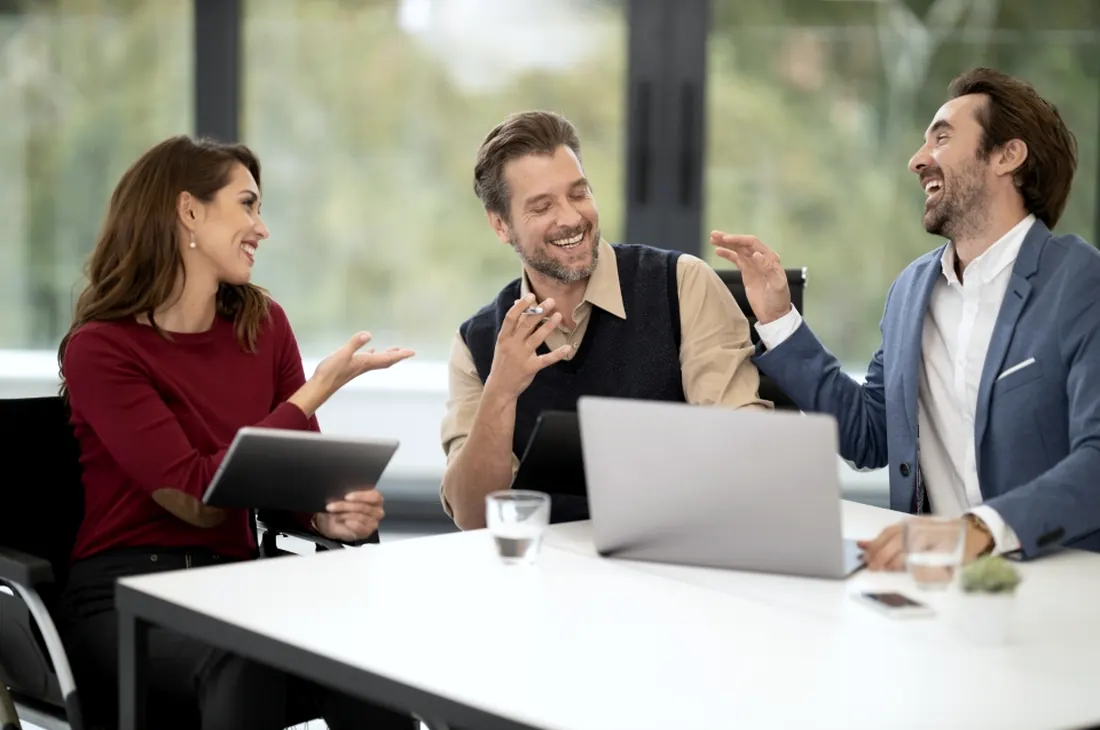 Colleagues in discussion around a table in a modern office