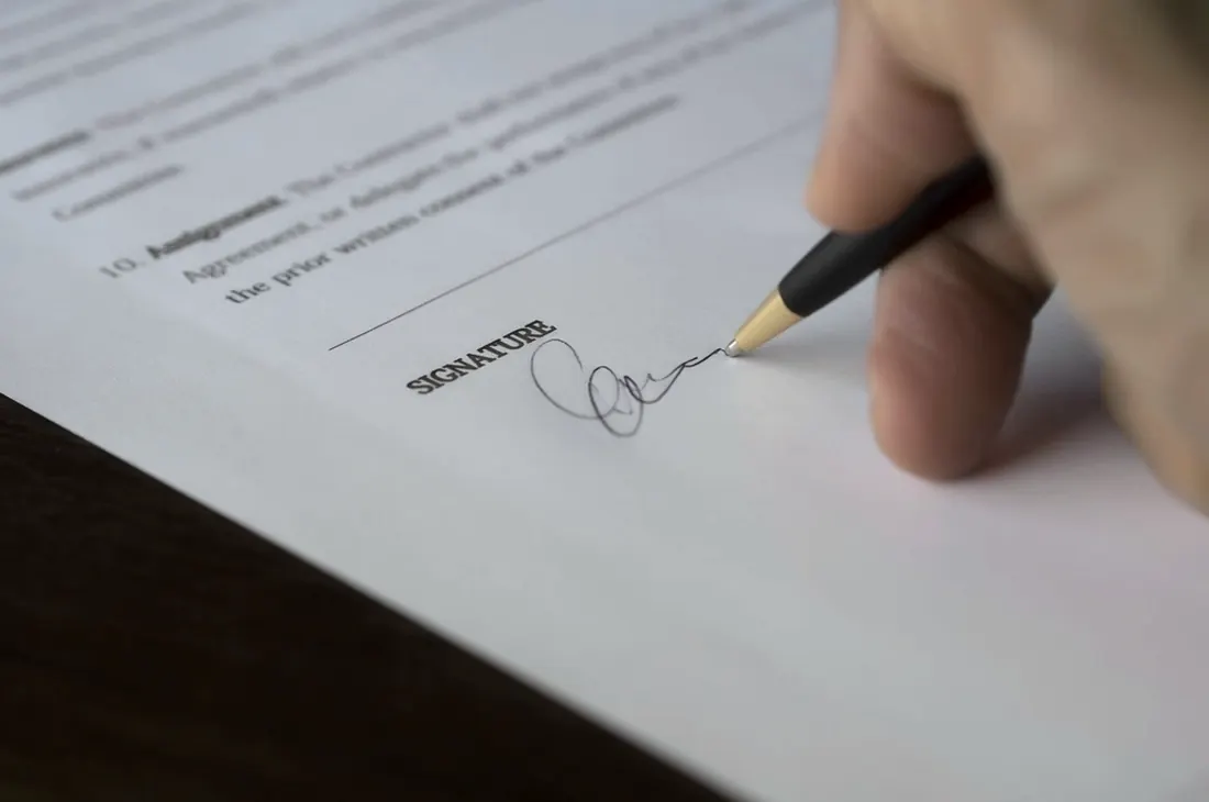 A document being signed with a fountain pen